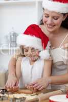 Mother and little girl baking Christmas cakes