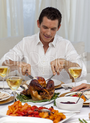 Attractive man eating turkey in Christmas dinner