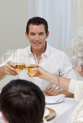 Attractive man toasting with his mother in a dinner