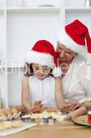 Grandmother and little girl baking Christmas cakes