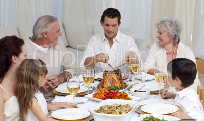 Father serving turkey to his family in a dinner