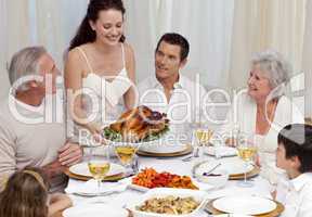 Woman showing turkey to her family for Christmas dinner