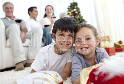 Children lying on floor with their family in Christmas