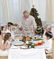 Family celebrating Christmas dinner with turkey at home