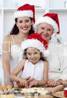 Daughter, mother and grandmother baking Christmas cakes