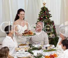Woman showing turkey to her family for Christmas