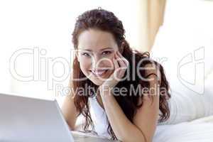 Beautiful woman using a laptop in bed