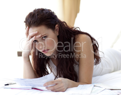 Beautiful woman in bed getting frustrated with bills