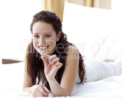 Beautiful woman in bed holding a pill