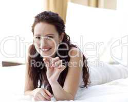 Beautiful woman in bed holding a pill