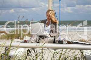 Beautiful Young Woman Using Laptop On Boat At The Beach