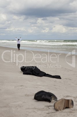 Businessman Leaving Clothes On Beach and Running Towards The Sea