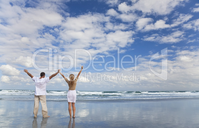 Man and Woman Couple Celebrating Arms Raised On A Beach