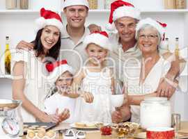 Children baking Christmas cakes in the kitchen with their family