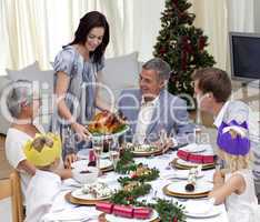 Happy family celebrating Christmas dinner with turkey