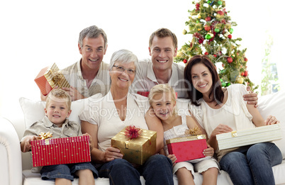 Family holding Christmas presents at home