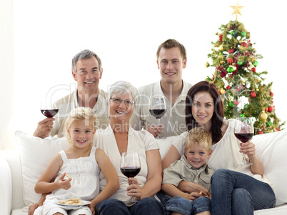 Family drinking wine and eating sweets in Christmas