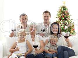 Family drinking wine and eating sweets in Christmas