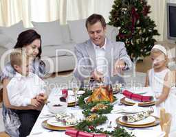 Father cutting a turkey in Christmas dinner