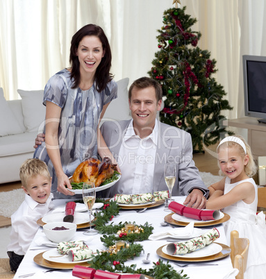Parents and children celebrating Christmas dinner with turkey
