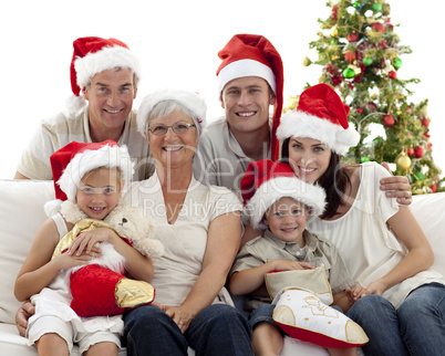 Children sitting with their family holding Christmas boots