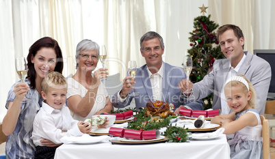 Family tusting in a Christmas dinner with white wine