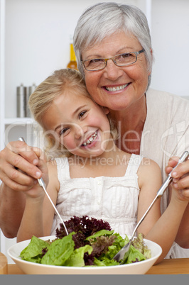 Happy grandmother eating a salad with granddaughter
