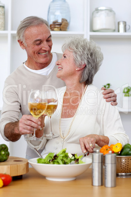Senior couple in love eating a salad in the kitchen