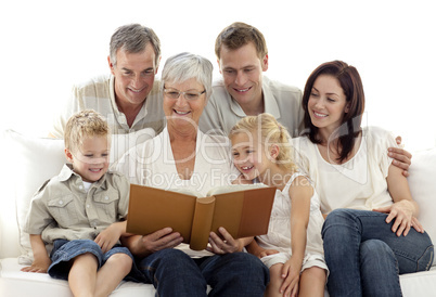 Grandmother reading a book to her family