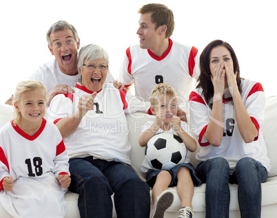 Family watching a football match in television