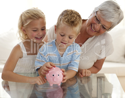 Grandmother and children saving money in a piggybank