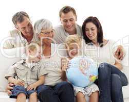 Big family on sofa looking at a terrestrial globe