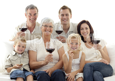 Family in living-room drinking wine and eating biscuits