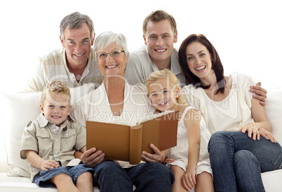Grandmother reading a book to her children and parents