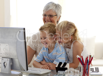 Children using a computer with their grandmother