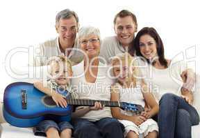 Portrait of family playing guitar at home