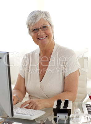 Smiling senior woman working with a computer