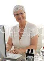 Smiling senior woman working with a computer