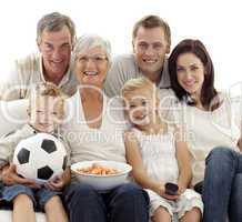 Family watching a football match at home