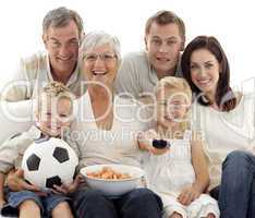 Happy family watching a football match at home