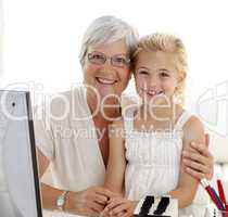 Portrait of granddaughter and grandmother using a computer