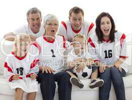 Excited family watching a football match in television