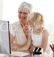 Granddaughter using a computer with her grandmother