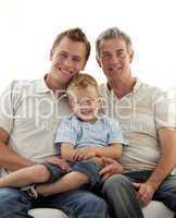 Smiling son, father and grandfather sitting on sofa