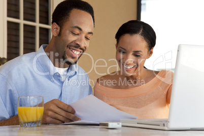 Happy African American Couple Working on Laptop Computer With Pa