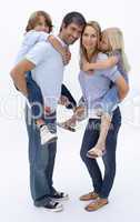 Father and mother giving boy and girl piggyback ride