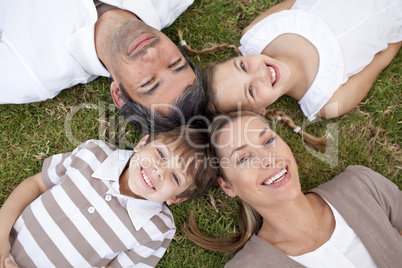 Smiling family lying in a park