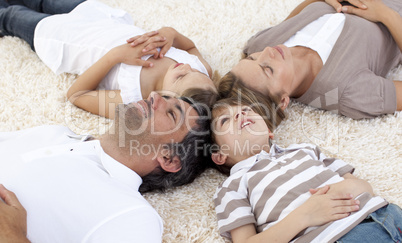 Family lying on floor at home with heads together