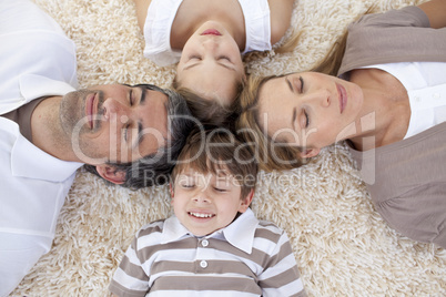 Family sleeping on floor with heads together
