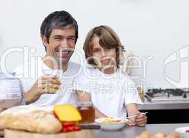 Happy father and son having breakfast together